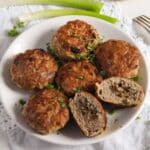polish mushroom-stuffed meatballs on a white plate, one is cut to show the filling.