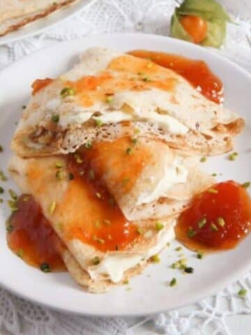 polish crepes nalesniki filled with sweet cheese and topped with apricot jam.