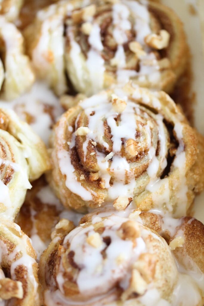 close up cinnamon pastries drizzled with icing