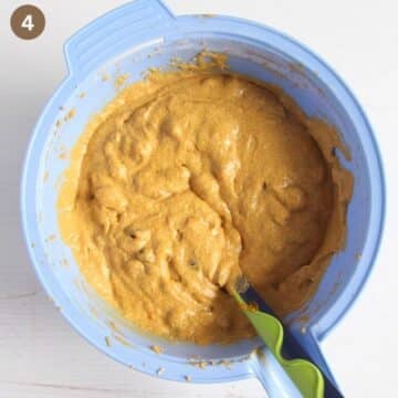batter for fruitcake with pumpkin puree in a bowl with a spatula in it.