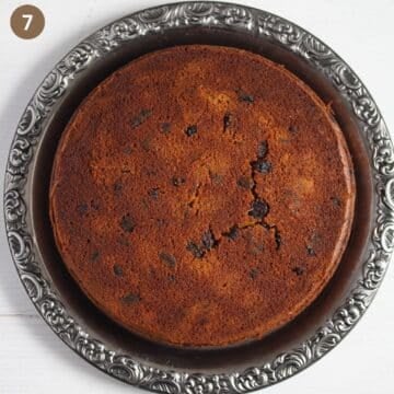 baked but undecorated fruitcake with pumpkin on a silver platter.