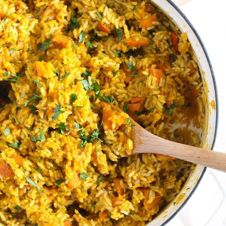 brightly colored pumpkin rice in a dutch oven seen from above