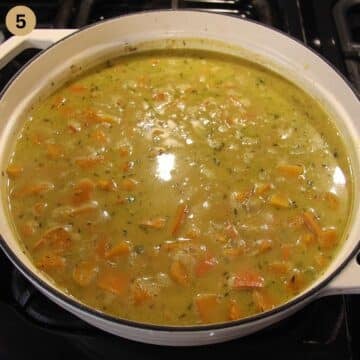simmering rice with pumpkin pieces in a dutch oven.