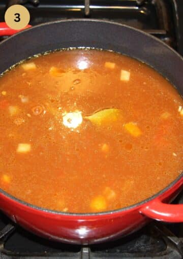 adding broth to soup in a large pot.