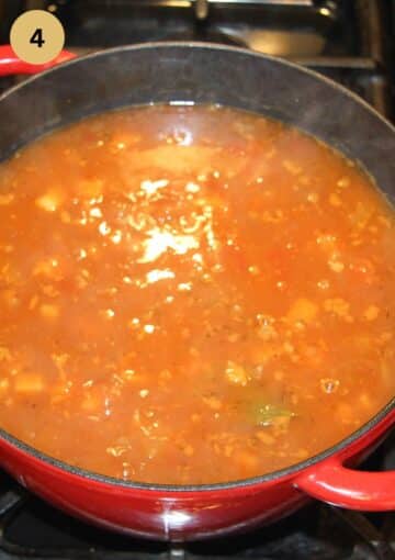 simmering soup in a large red dutch oven.