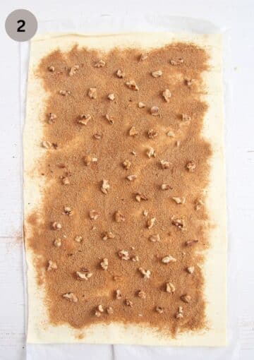 a puff pastry sheet covered with cinnamon sugar and chopped walnuts.