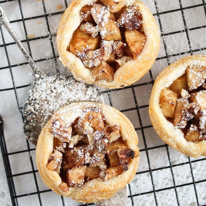 three puff pastry apple pies on a wire rack