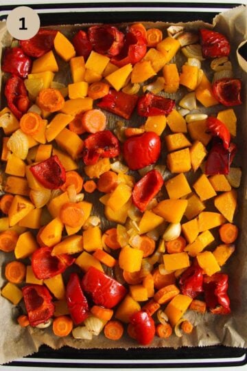 roasted butternut squash, pepper, and carrot pieces for soup on a baking sheet.