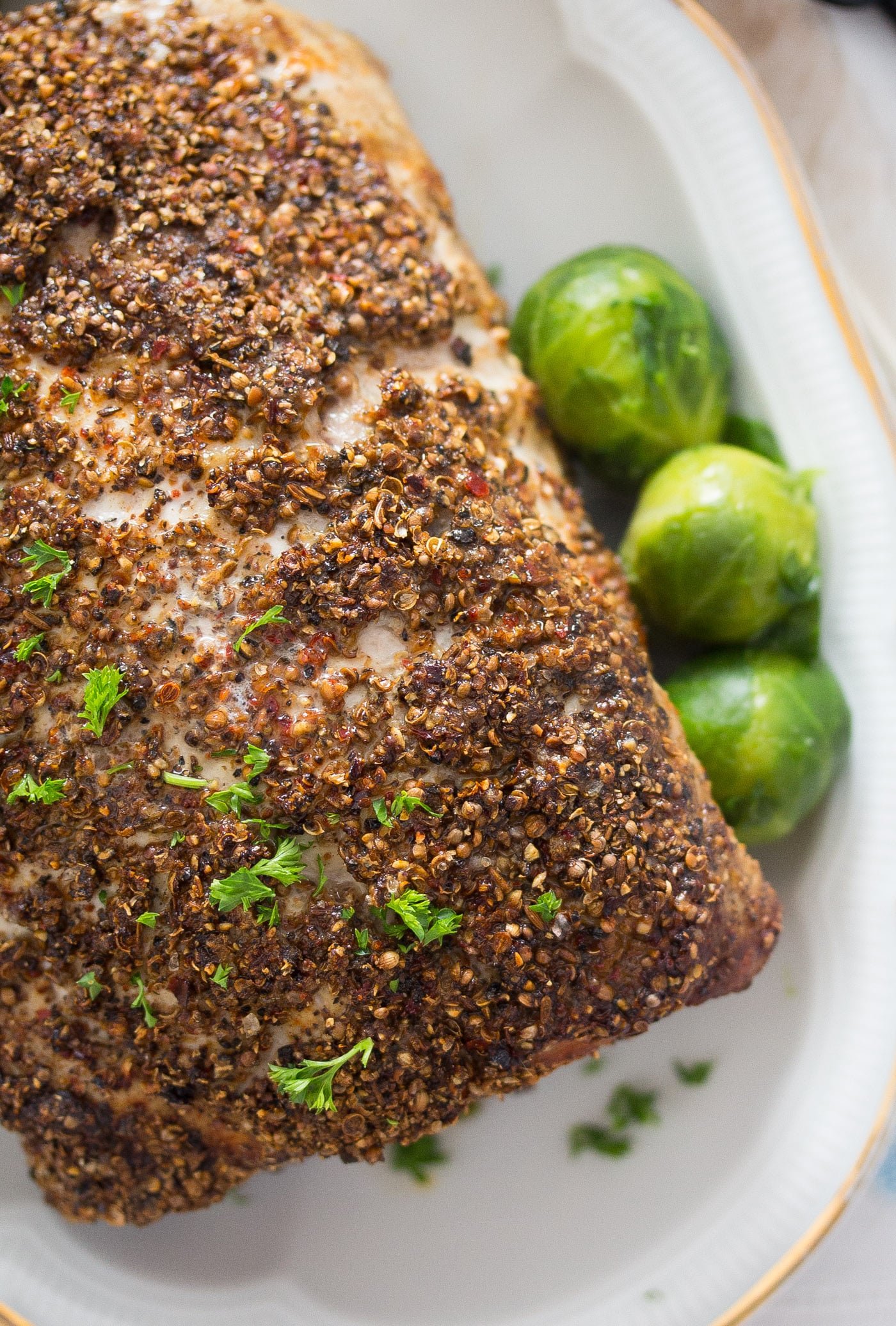 close up crusted boneless pork loin with brussels sprouts