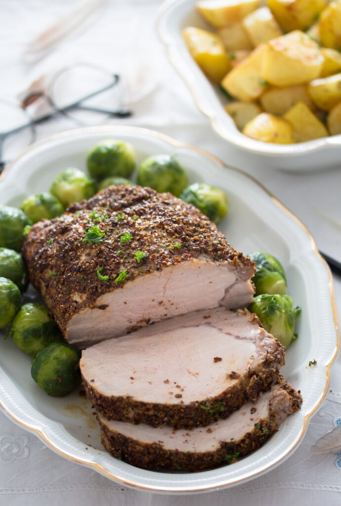 sliced boneless pork loin roast served with sprouts and potatoes