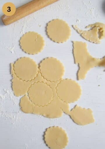 cutting cookie dough to make german biscuits, a rolling pin beside it.
