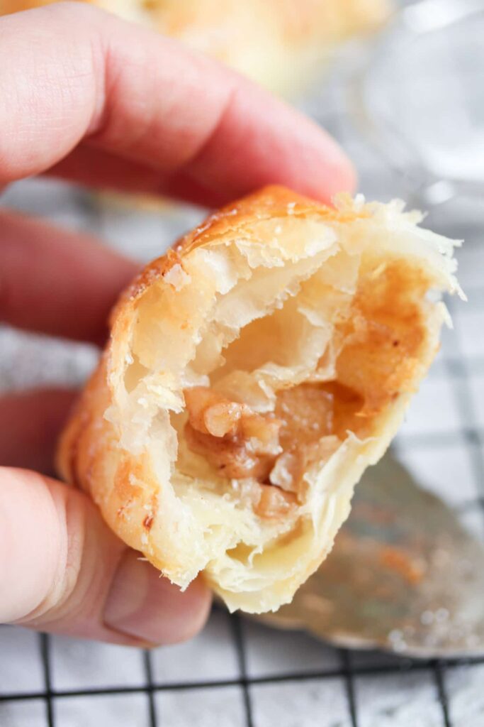 hand holding half of apple filled pastry