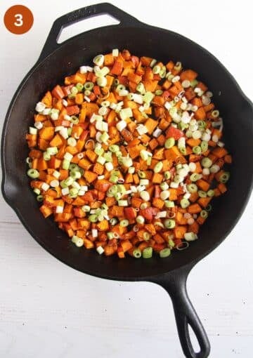 half-cooked pumpkin pieces and chopped green onions in a skillet for making frittata.