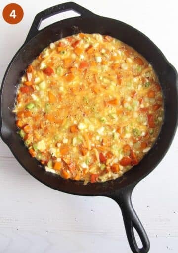 frittata with pumpkin and cheese uncooked in a cast iron skillet.