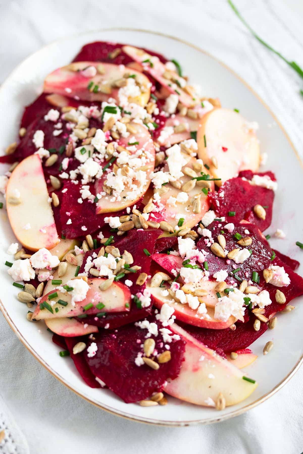 slices of raw beetroot and apples sprinkled with crumbled feta and herbs.