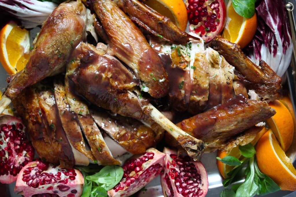 close up thanksgiving platter with turkey, oranges and pomegranates