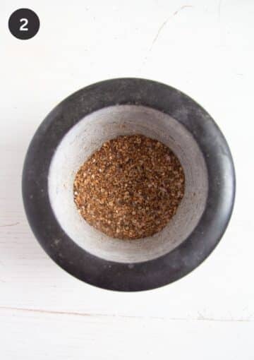 roasted whole spices in a mortar.