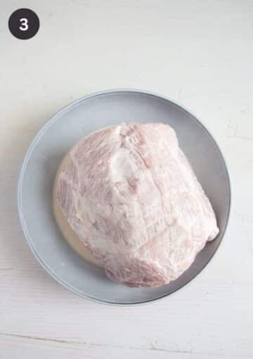 one pork loin smeared with heavy cream on a plate.