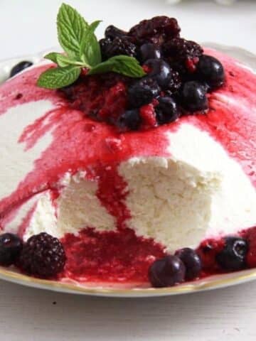 yogurt bomb dessert with berry sauce dripping.