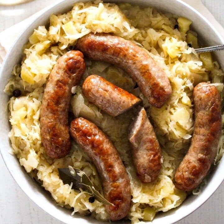 brats in the oven in a bowl with sauerkraut