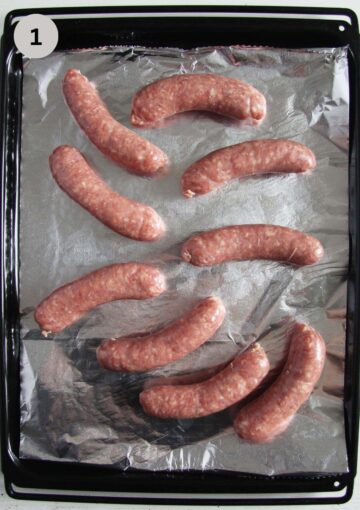 raw bratwurt on a baking tray lined with foil.
