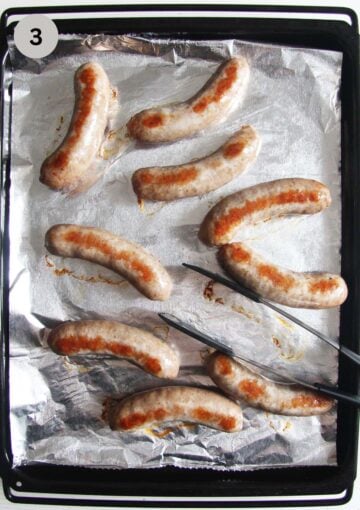 baked brats on a baking sheet lined with foil.