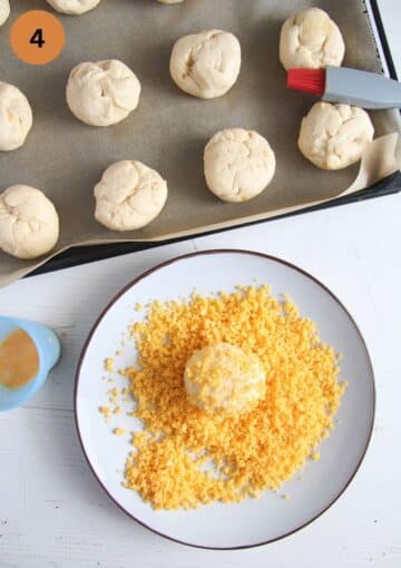 rolling yeast dough balls in grated cheddar.