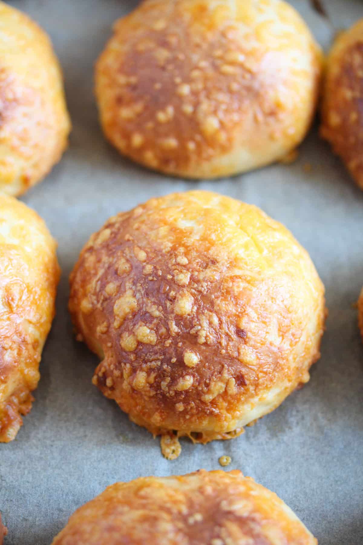 many golden brown cheese buns with cheese inside and outside.