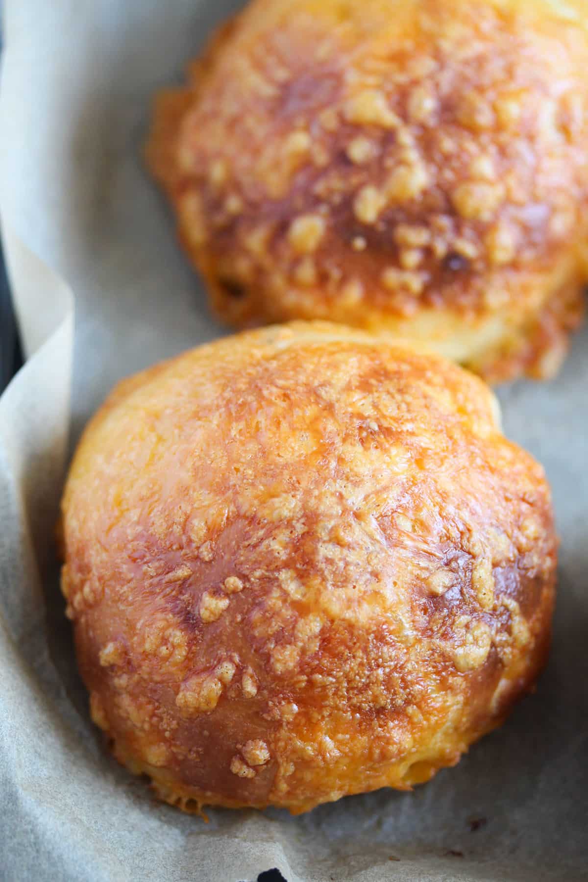 two golden brown homemade cheese buns.