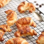 chocolate puff pastry mini croissants on a wire rack.