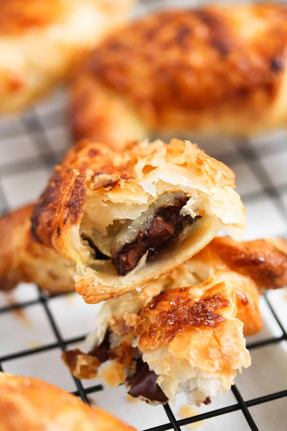 one puff pastry piece torn to show the melty chocolate filling.