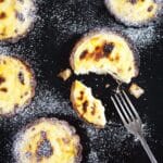 hokkaido cheese tarts on a black board and a fork.