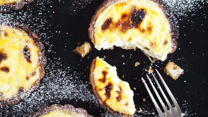 hokkaido cheese tarts on a black board and a fork.