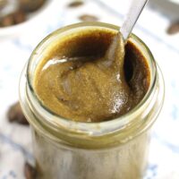 pumpkin seed butter stirred in jar with a tablespoon