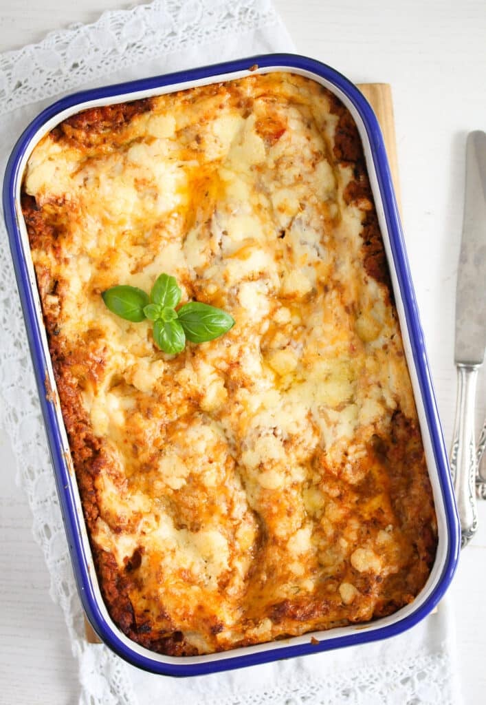 lasagna in a baking dish with meat sauce and bechamel