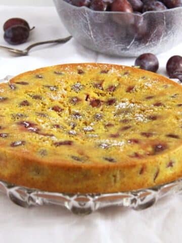 round turmeric cake with plums in it.