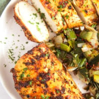 chicken breast without breading served with cooked leeks.