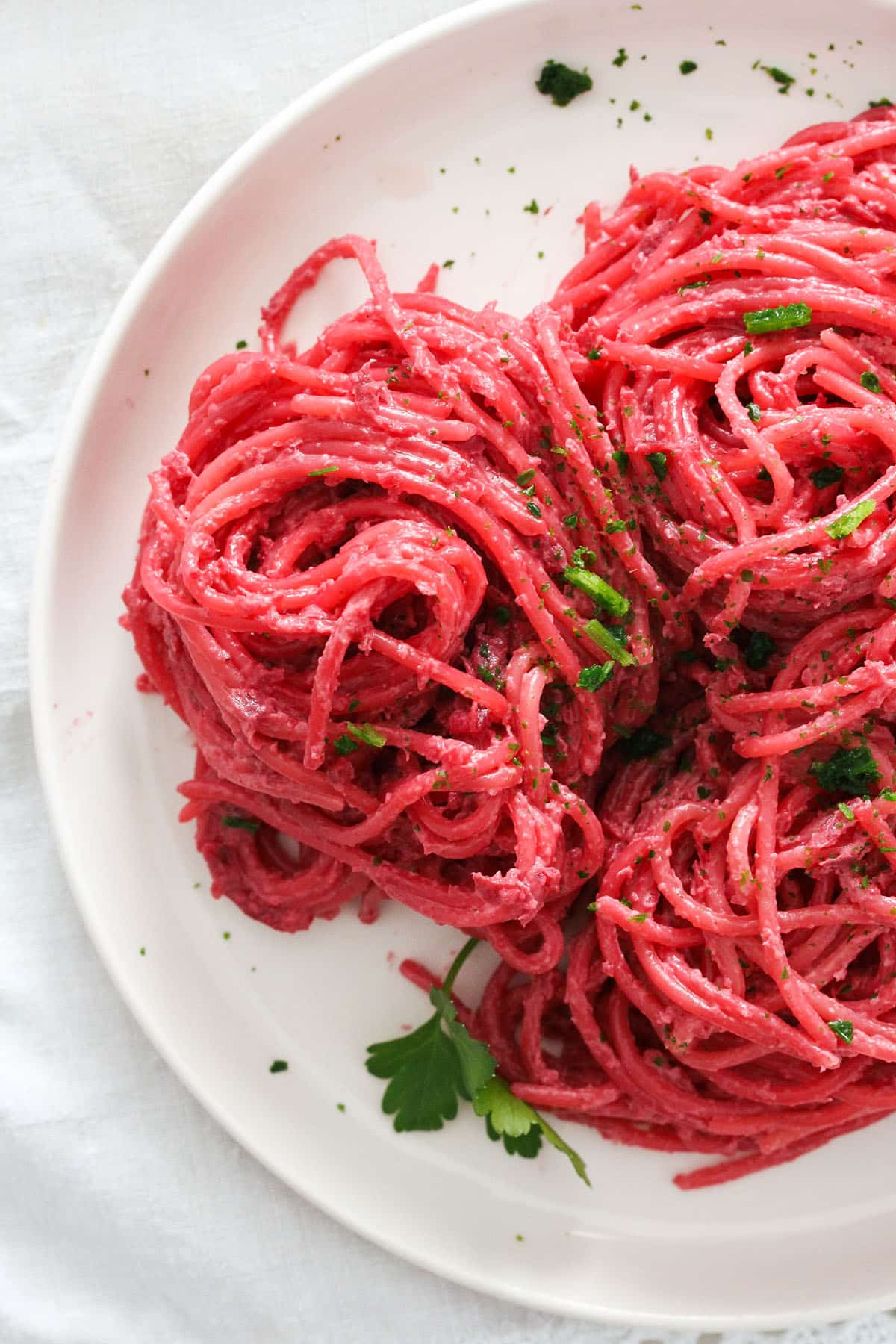tangled spaghetti with beetroot sauce and parsley on a plate.