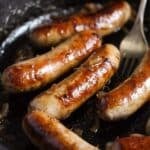 stove top brats in a cast iron pan.