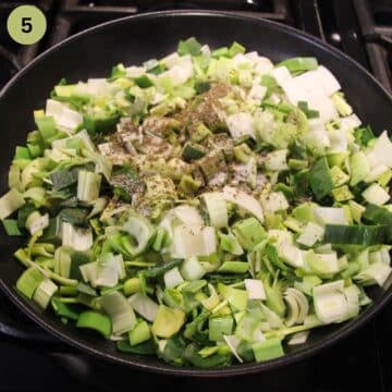 chopped leeks and spices in a pan before cooking.
