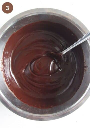 mixing shiny chocolate mixture to make champagne chocolate truffles with a spoon.