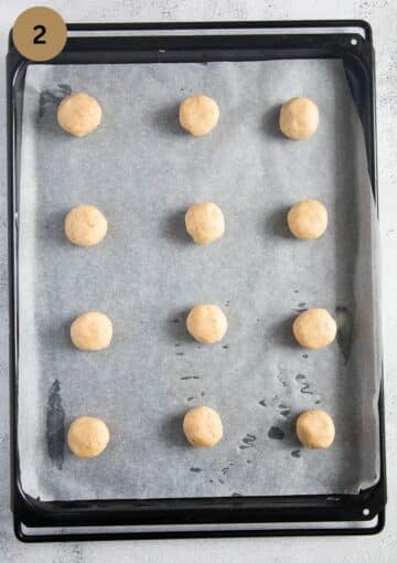 balls of unbaked cookie dough on a baking tray.