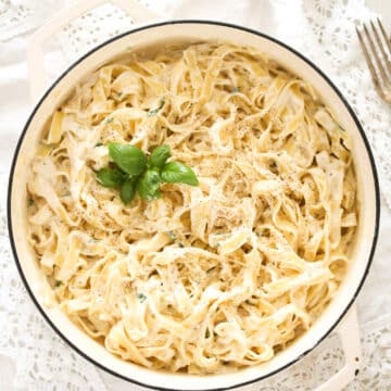 overhead picture of a white pot with pasta with cream cheese sauce.