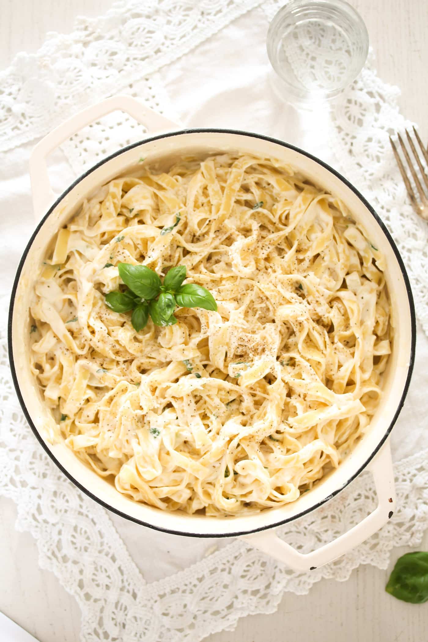 overhead picture of a white pot with pasta with cream cheese sauce.