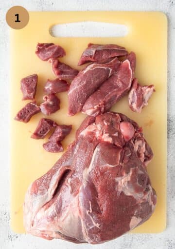 chopping lamb shoulder meat into cubes.