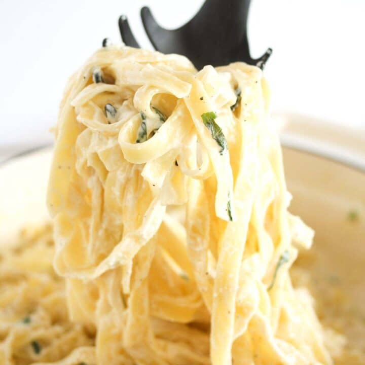 cream cheese pasta held on a serving spoon.