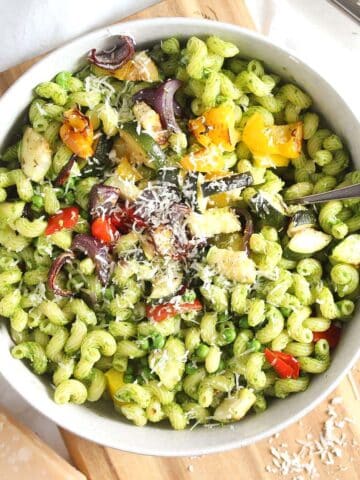 vegetable pesto pasta with parmesan in a white bowl