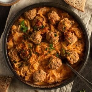german meatballs with sauerkraut in a large bowl with a spoon in it.