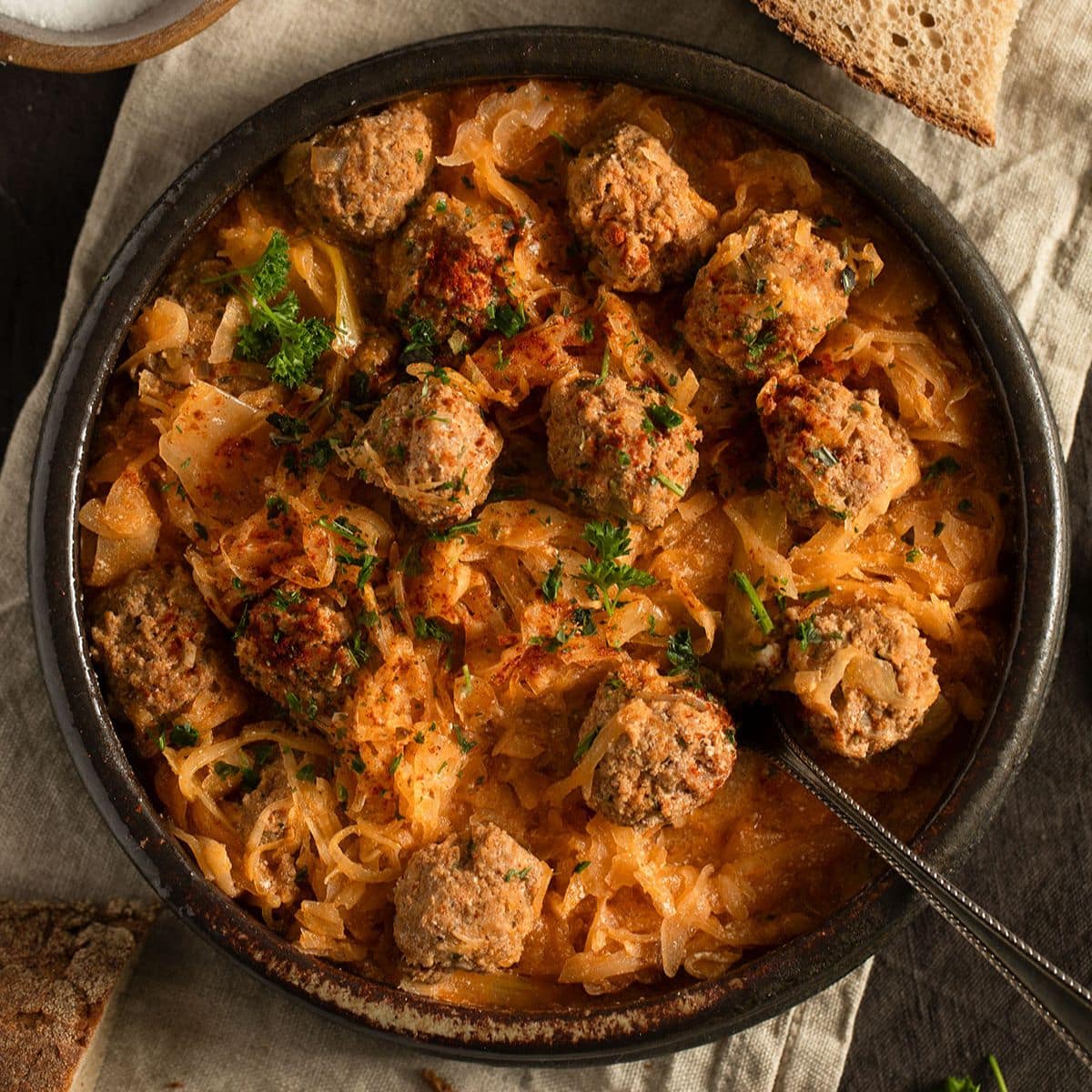 german meatballs with sauerkraut in a large bowl with a spoon in it.