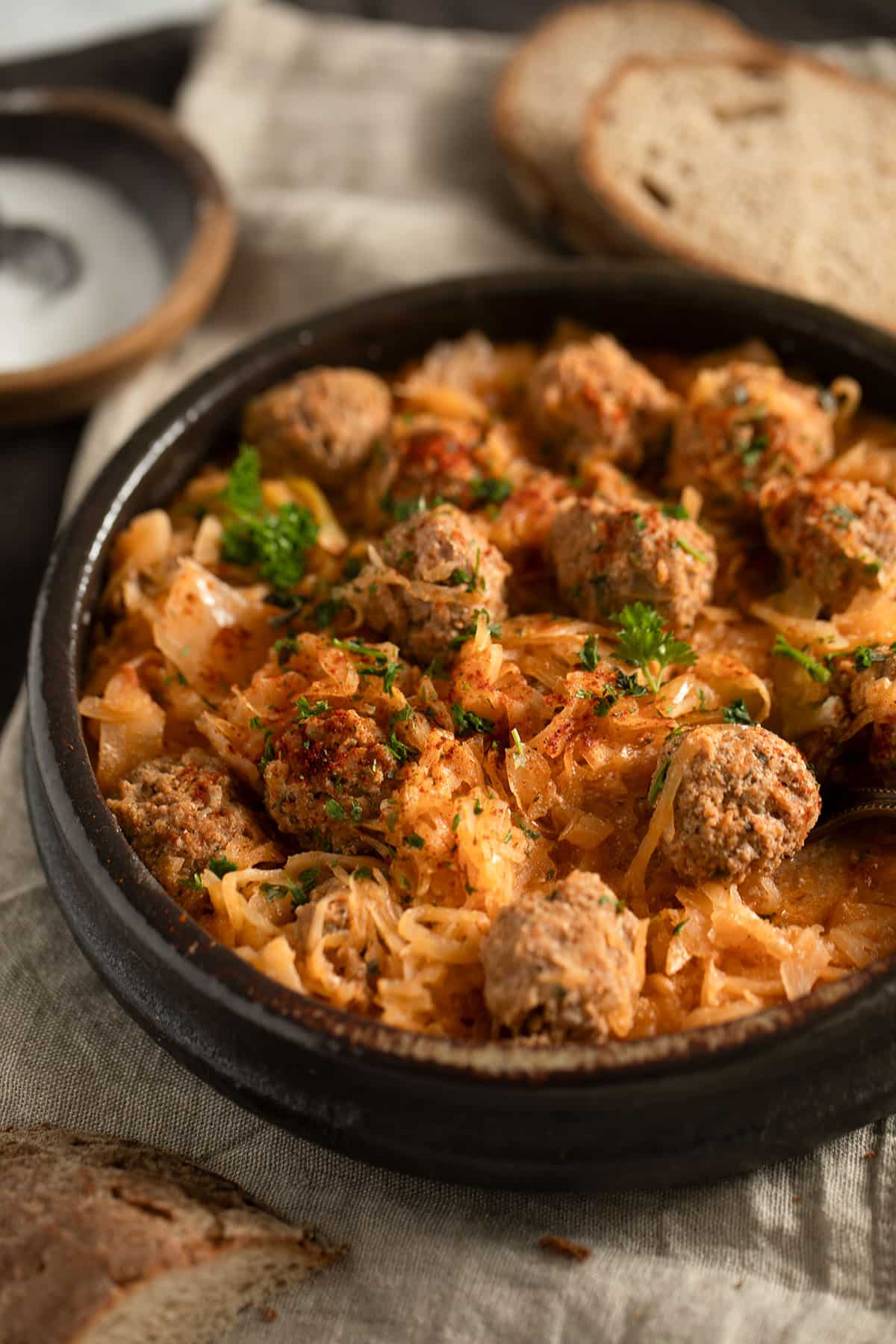 many german meatballs cooked with sauerkraut in a large bowl.